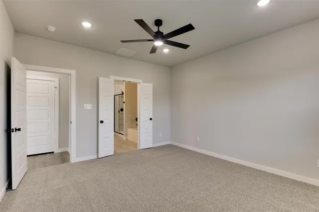 an empty room with closet and ceiling fan