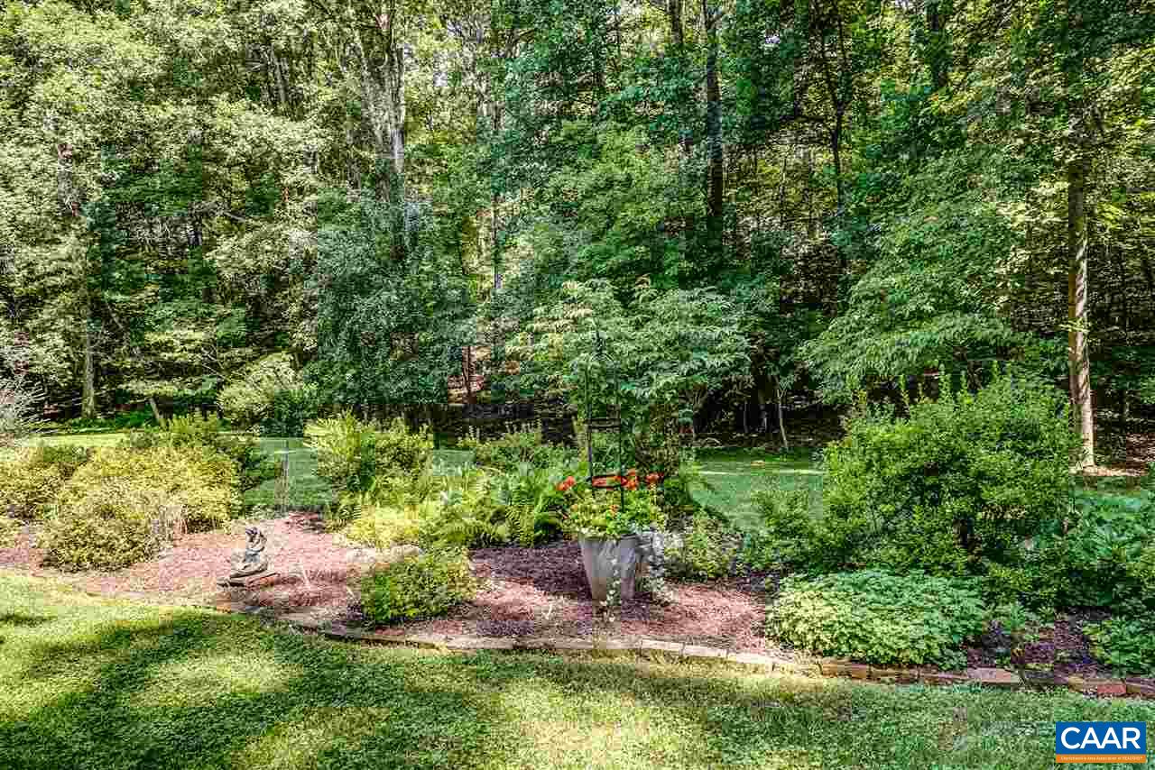 1075 Richmond Road Keswick, VA 22947 - Photo 46 of 50 a view of a garden with plants and large trees