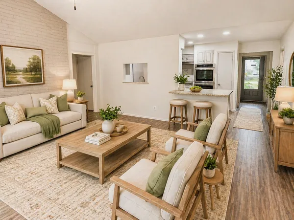 a living room with furniture a flat screen tv and kitchen view