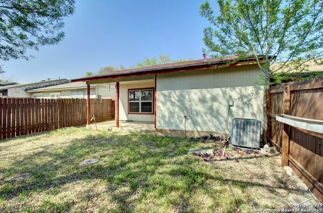 a backyard of a house with table and chairs