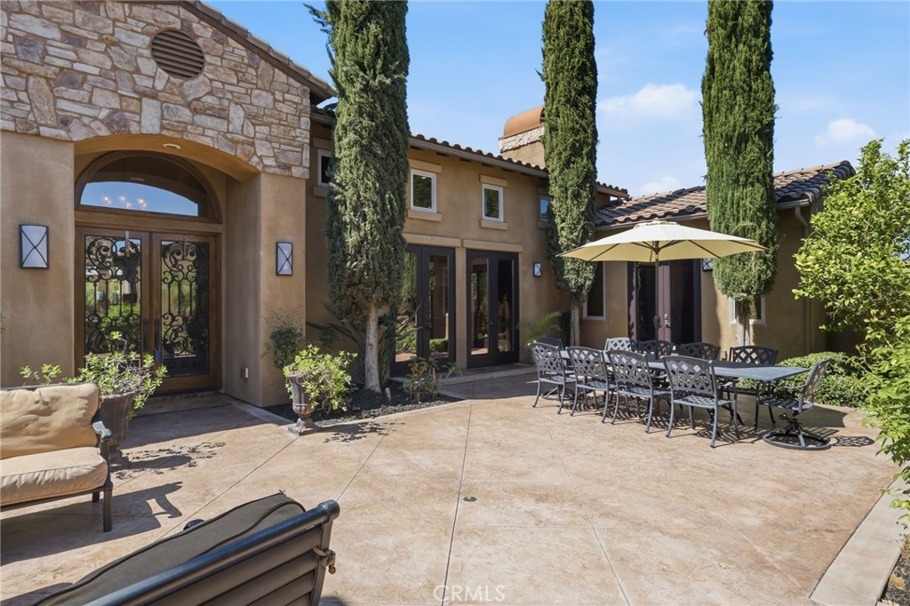 14779 Wood Riverside, CA 92508 - Photo 8 of 70 a patio with a table and chairs under an umbrella