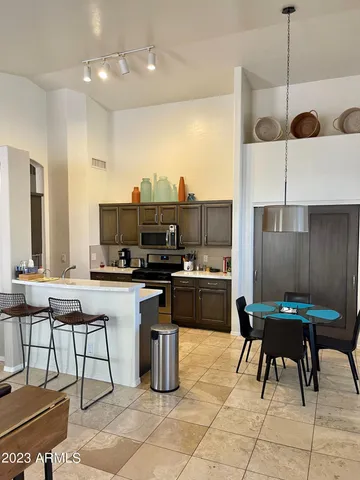 a kitchen with stainless steel appliances kitchen island granite countertop a sink and a refrigerator