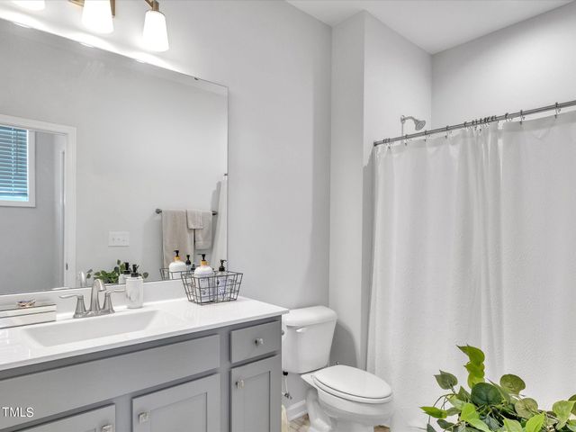 a bathroom with a granite countertop sink a toilet and a mirror