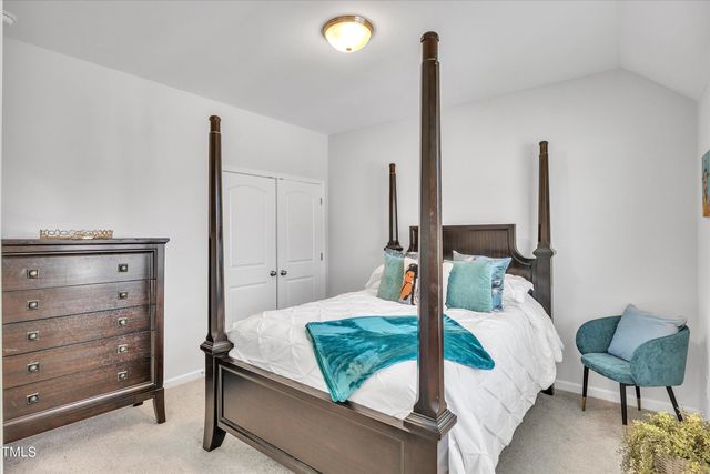 a bedroom with a bed window and chair