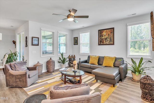 a living room with furniture potted plant and window
