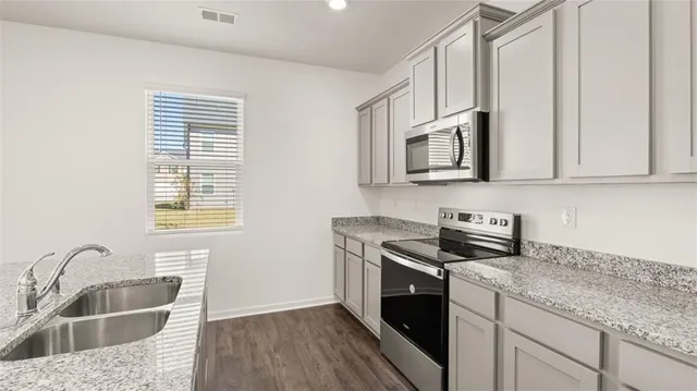 a kitchen with stainless steel appliances granite countertop a sink stove and cabinets