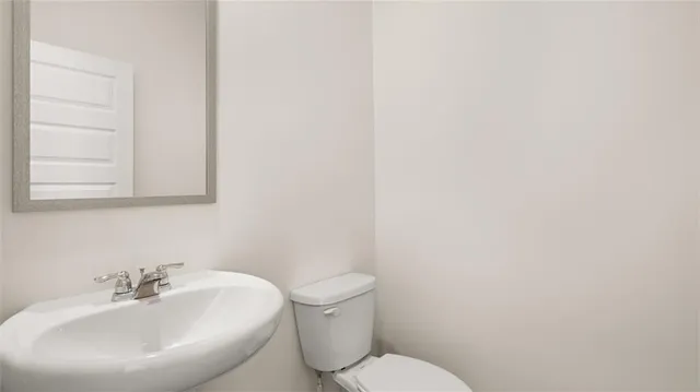 a bathroom with a toilet a sink and mirror