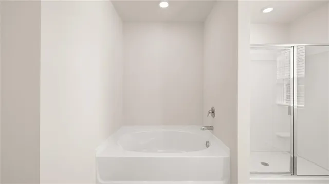 a white bath tub sitting next to a shower