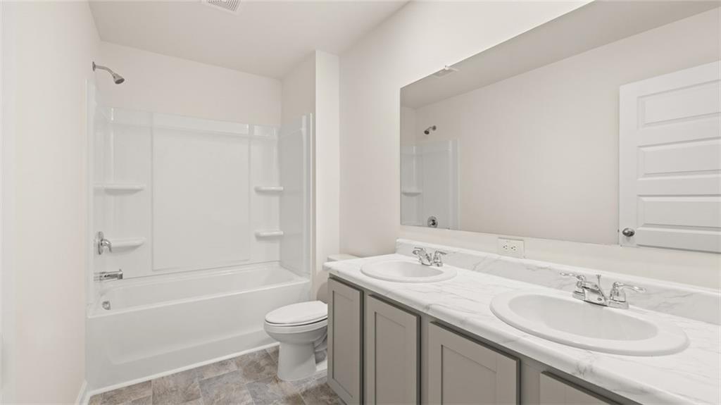 69 White Spruce Way Newnan, GA 30265 - Photo 35 of 40 a bathroom with a granite countertop sink a toilet and shower
