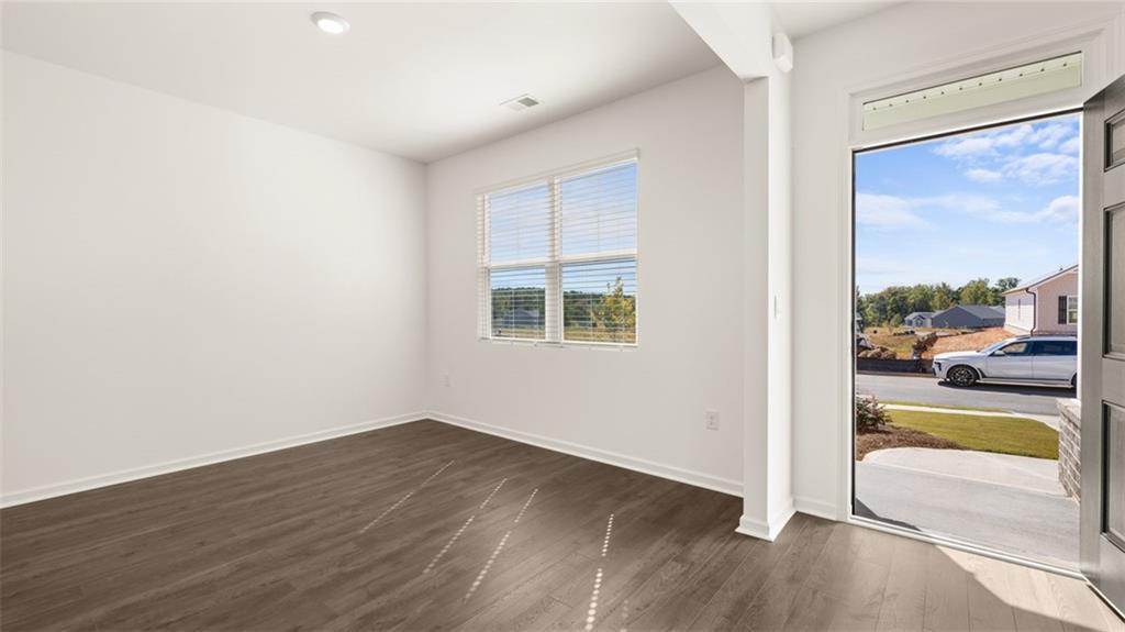 69 White Spruce Way Newnan, GA 30265 - Photo 4 of 40 an empty room with wooden floor and windows