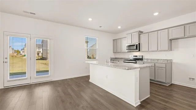 a kitchen with appliances a sink and cabinets