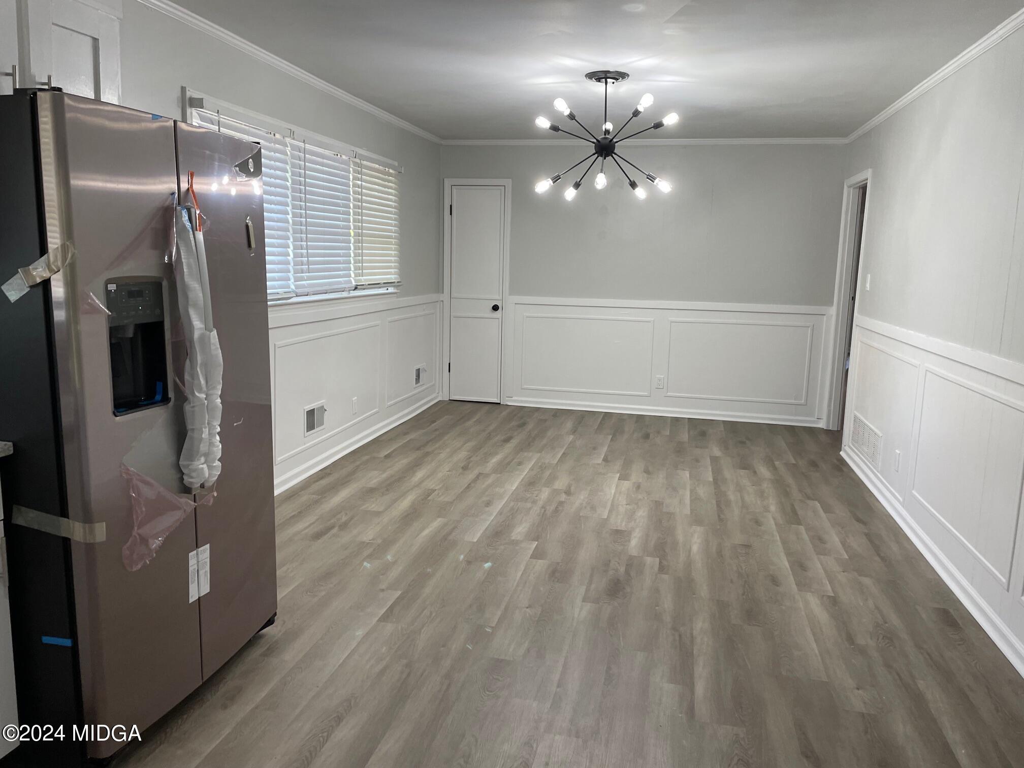 2069 Manson Road Macon, GA 31217 - Photo 4 of 15 a view of an empty room with wooden floor and a kitchen