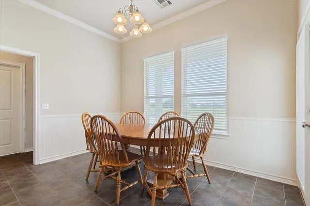 a view of a dining room with furniture and chandelier