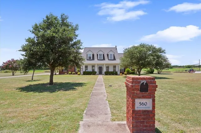 a sign board with a yard in the back