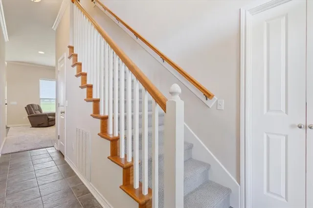 a view of staircase with lots of frames on wall and windows