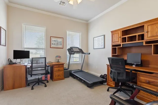a view of a workspace with furniture and a window
