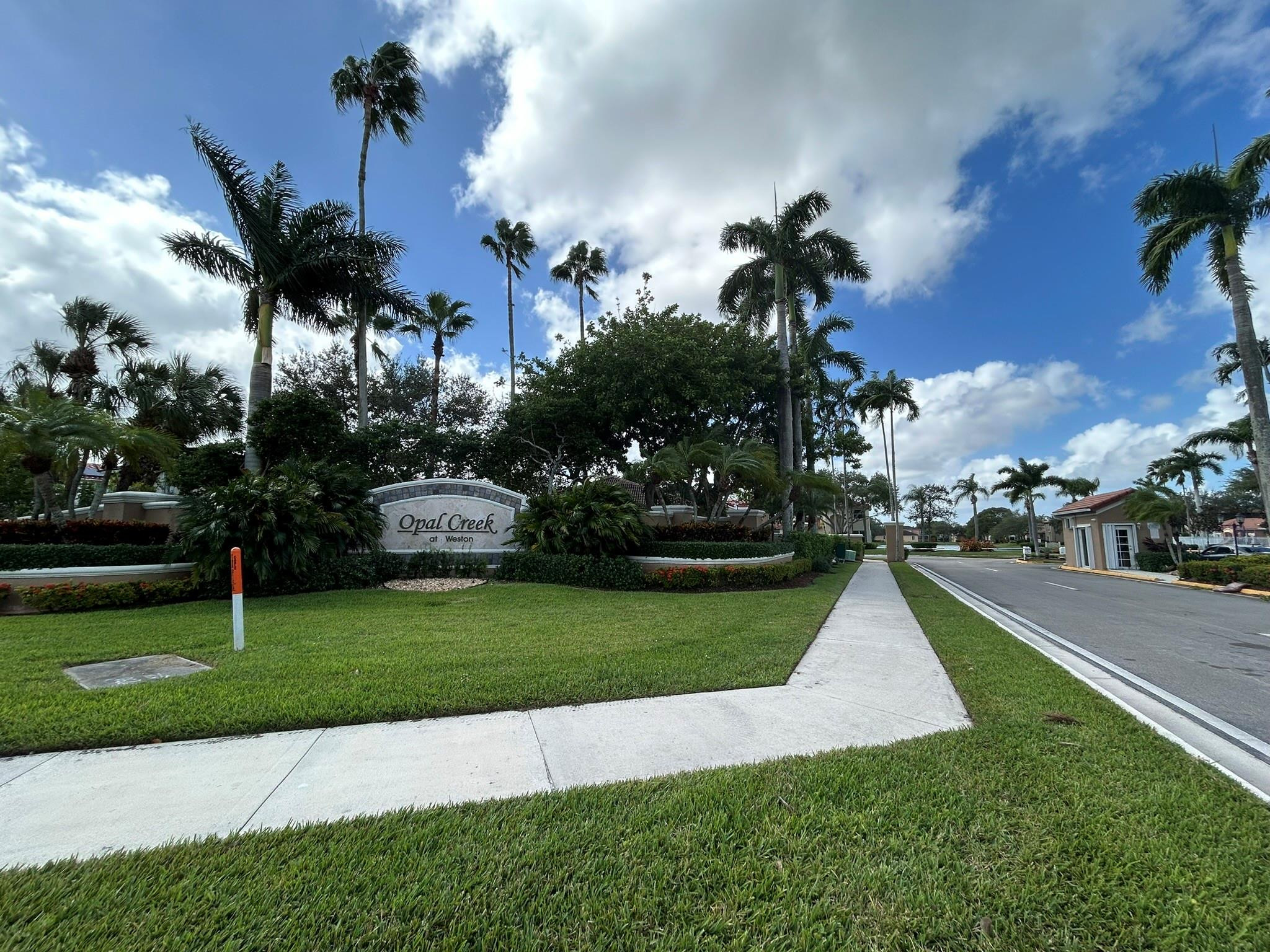 16223 Emerald Cove Road, Unit 16223 Weston, FL 33331 - Photo 38 of 38 a front view of a house with a garden and trees