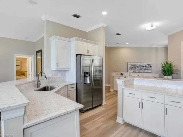 a kitchen with stainless steel appliances granite countertop a refrigerator and a sink