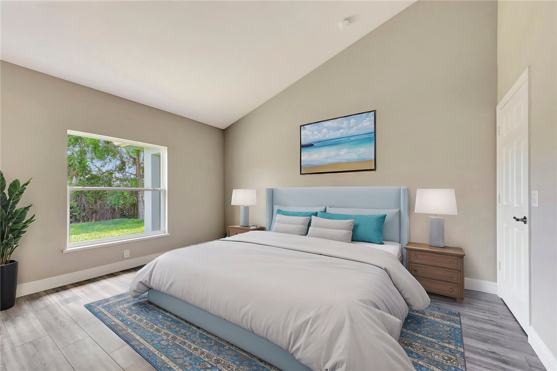 11126 Roseland Road Sebastian, FL 32958 - Photo 4 of 7 a bedroom with a large bed and a window