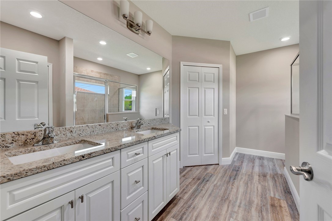 11126 Roseland Road Sebastian, FL 32958 - Photo 5 of 7 a spacious bathroom with a granite countertop sink a mirror and a