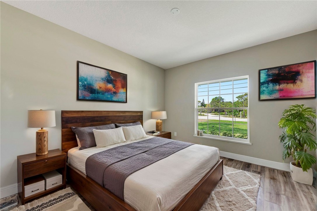 11126 Roseland Road Sebastian, FL 32958 - Photo 6 of 7 a bedroom with a large bed and a potted plant