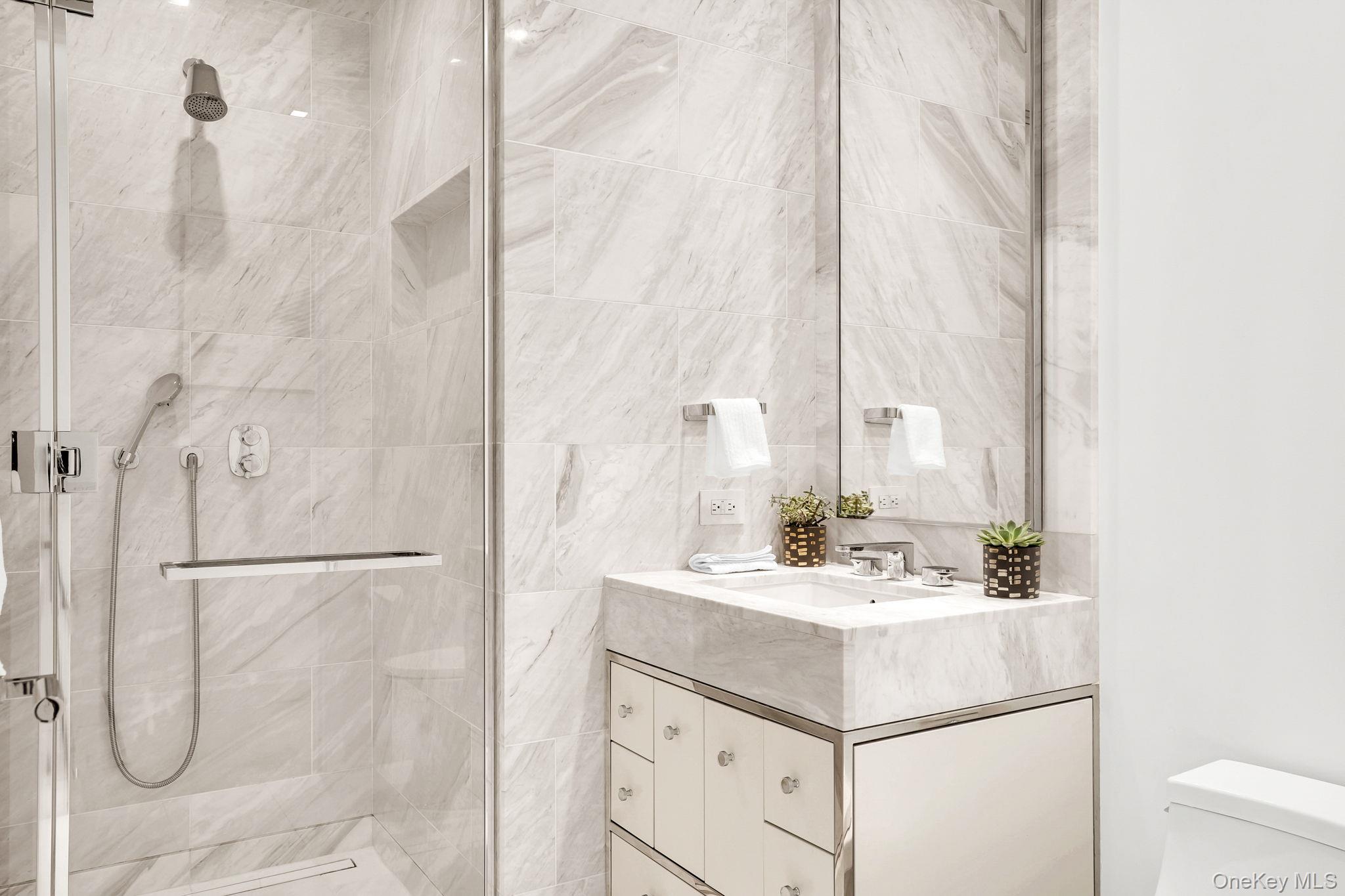 138 East 50th Street, Unit 26C Manhattan, NY 10022 - Photo 16 of 31 a bathroom with a sink vanity and tub
