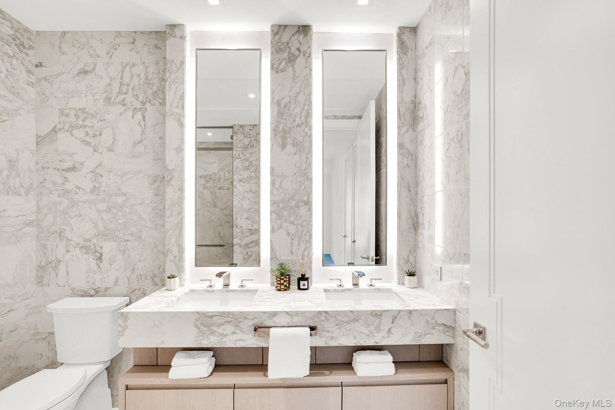 138 East 50th Street, Unit 26C Manhattan, NY 10022 - Photo 19 of 31 a bathroom with a double vanity sink and a mirror
