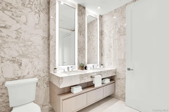 a bathroom with a double vanity sink mirror and toilet