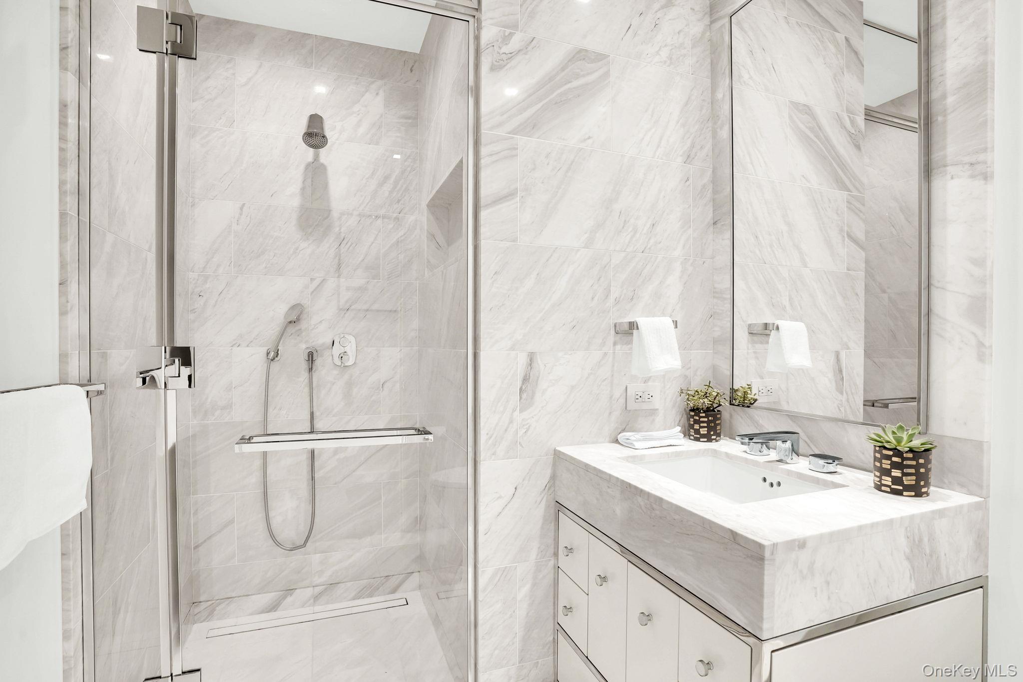138 East 50th Street, Unit 26C Manhattan, NY 10022 - Photo 27 of 31 a bathroom with a sink mirror and shower