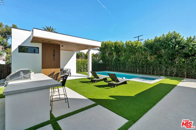 a view of a house with swimming pool and sitting area