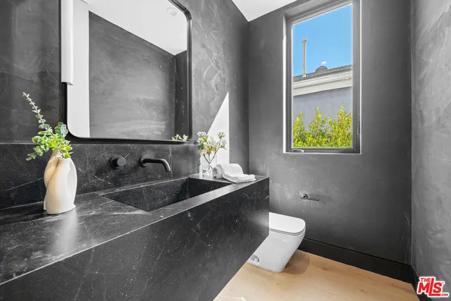 a bathroom with a toilet sink and mirror