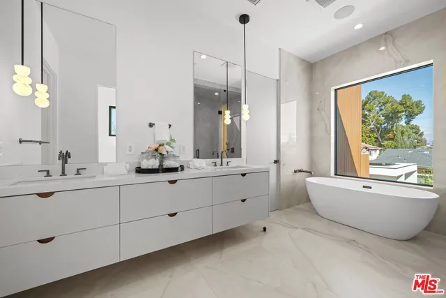 a bathroom with a double vanity sink bathtub and next to a window