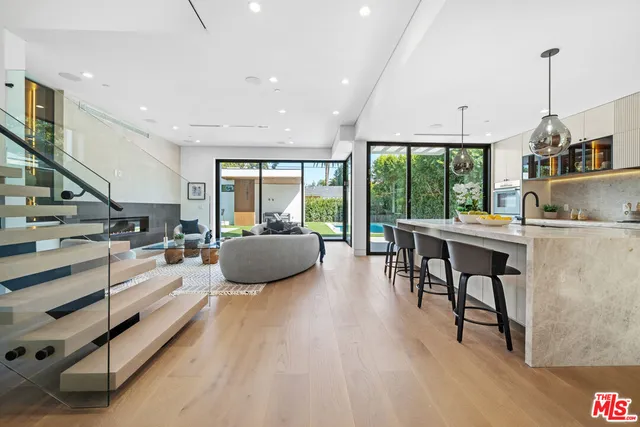 a kitchen with stainless steel appliances granite countertop sink stove and wooden floor