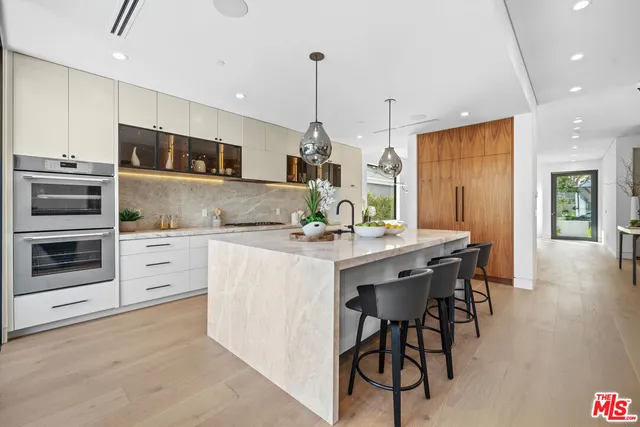 a kitchen with stainless steel appliances kitchen island granite countertop a stove a sink and a refrigerator