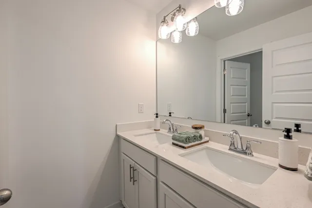 a bathroom with a double vanity sink mirror and shower