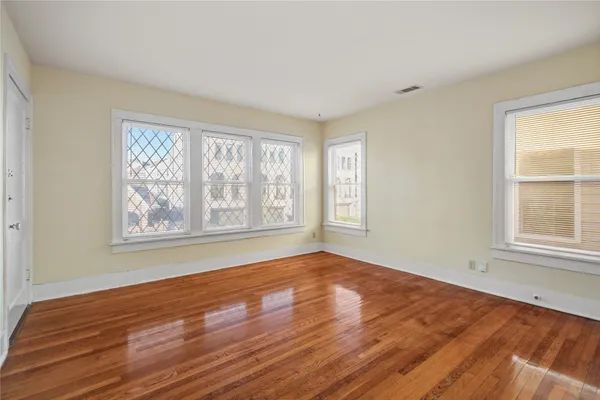 wooden floor in an empty room with a window