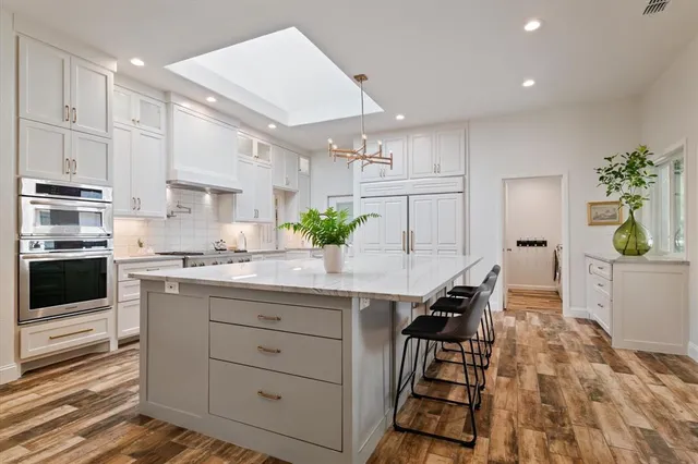 a kitchen with granite countertop white cabinets and white appliances