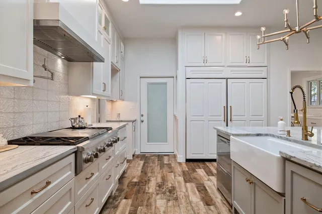 a kitchen with granite countertop a sink stove and cabinets