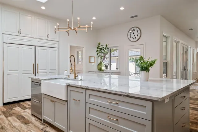 a kitchen with kitchen island granite countertop stainless steel appliances sink and cabinets