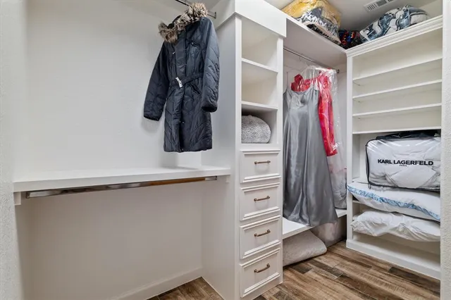 a view of walk in closet with clothes and shoes