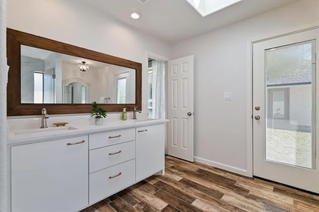 a spacious bathroom with a double vanity sink and a mirror