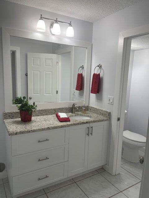 639 Executive Center Drive, Unit O107 West Palm Beach, FL 33401 - Photo 17 of 21 a bathroom with a granite countertop sink and a mirror