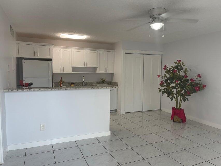 639 Executive Center Drive, Unit O107 West Palm Beach, FL 33401 - Photo 2 of 21 a utility room with cabinets washer and dryer