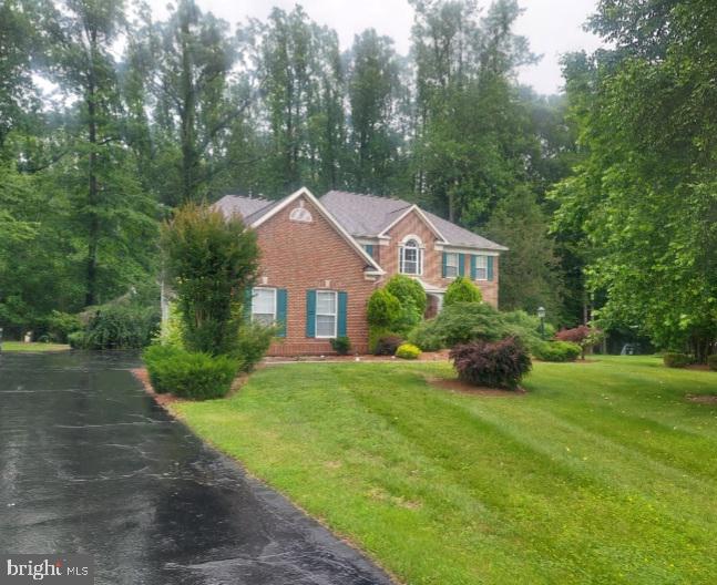a front view of a house with a yard and trees