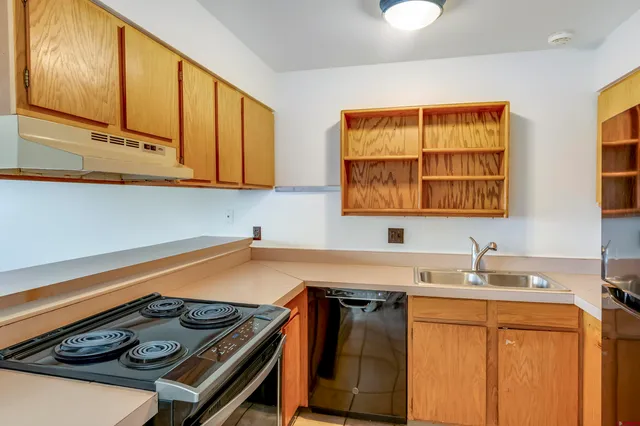 a kitchen with stainless steel appliances granite countertop a sink stove and cabinets