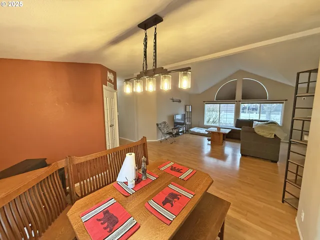 a living room with a table chairs and wooden floor