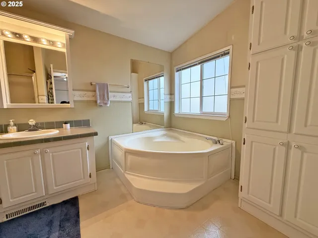 a bathroom with a granite countertop sink a mirror and shower
