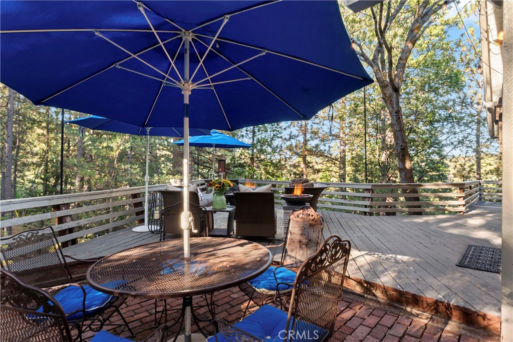 309 Castle Gate Road Lake Arrowhead, CA 92352 - Photo 53 of 58 a patio with a table and chairs under an umbrella