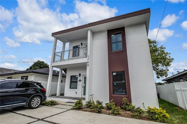 a car parked in front of white house