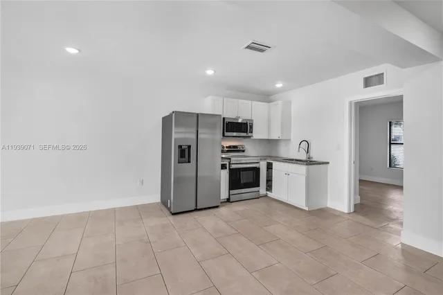 a kitchen with stainless steel appliances a refrigerator and a sink